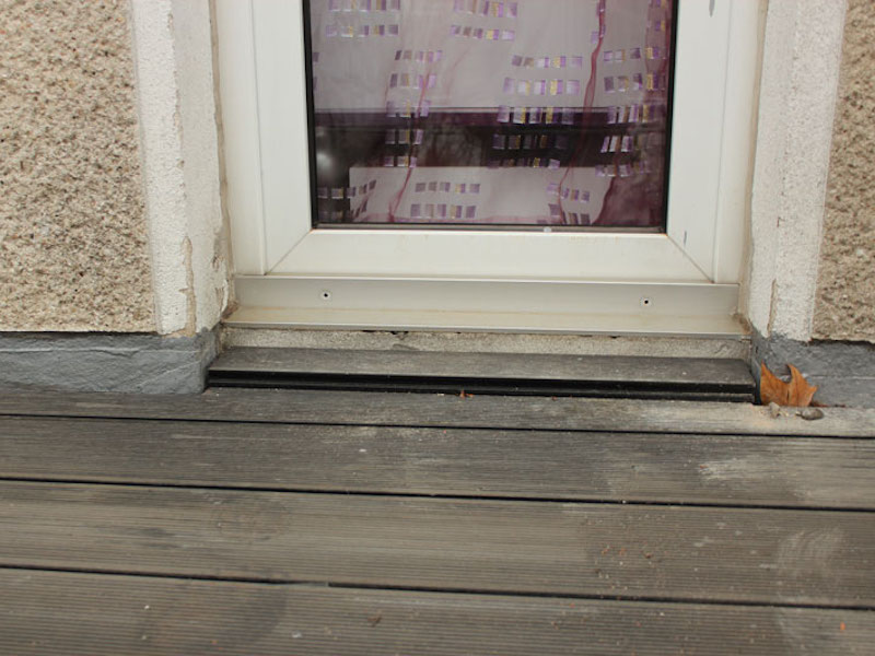 Instandsetzung einer Balkonabdichtung mit Flüssigkunststoff, nicht ausreichend hochgeführt, Balkontüren ausgespart, der Belag aus Holzoptikpaneelen ist neu